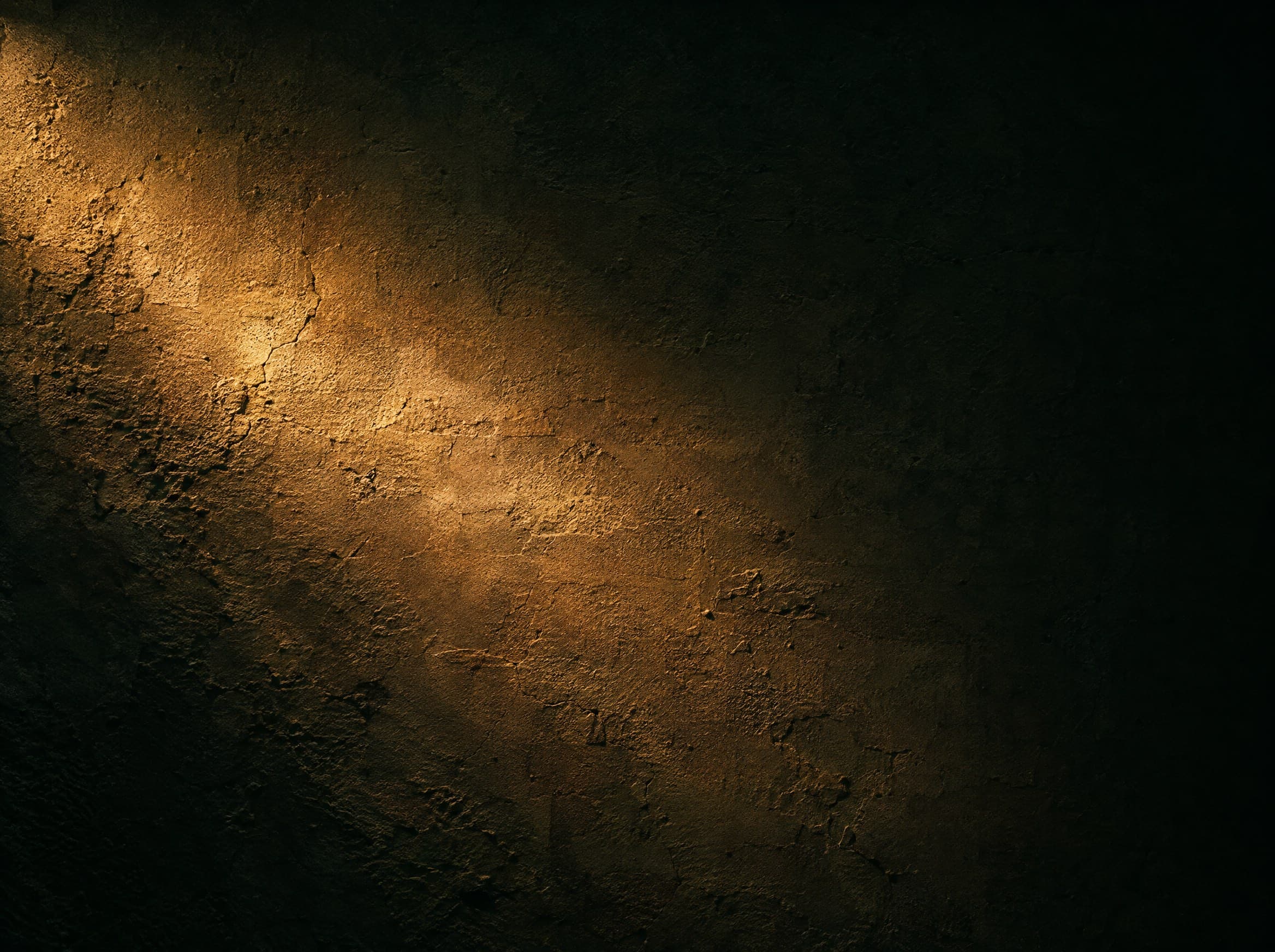 A single small warm light glowing alone in an immense dark space.